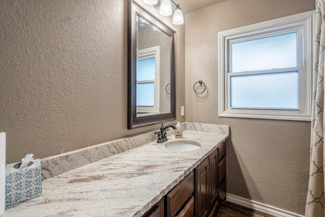 2205 Boyd Ave, Midland, TX 79705 - bathroom with a textured wall, vanity, and wood finished floors