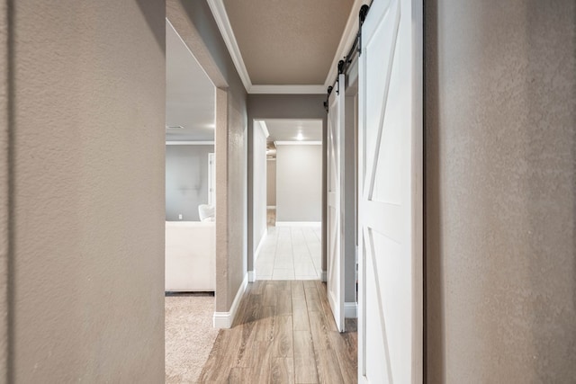 2205 Boyd Ave, Midland, TX 79705 - hall featuring ornamental molding, a barn door, a textured wall, and wood finished floors
