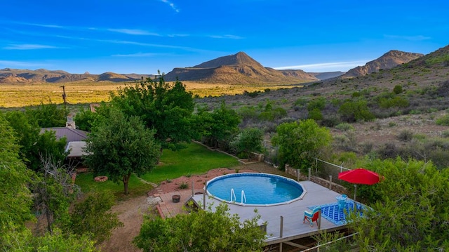 view of swimming pool with a deck with mountain view