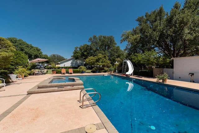 view of swimming pool featuring a pool with connected hot tub, a water slide, a patio, and fence