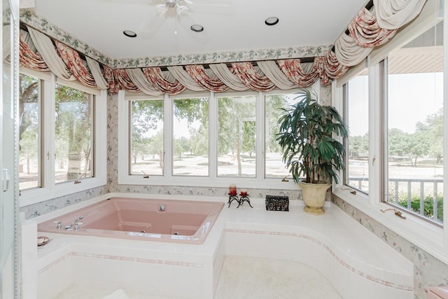 bathroom featuring a jetted tub, wallpapered walls, and plenty of natural light