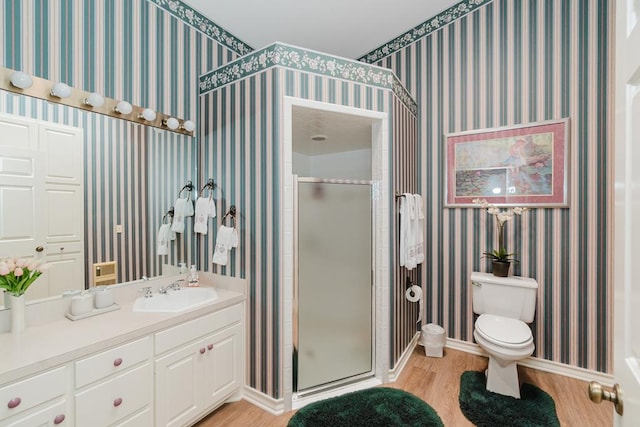 bathroom featuring a stall shower, wood finished floors, toilet, and wallpapered walls