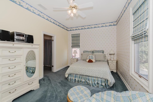 bedroom with ceiling fan, visible vents, baseboards, dark colored carpet, and wallpapered walls