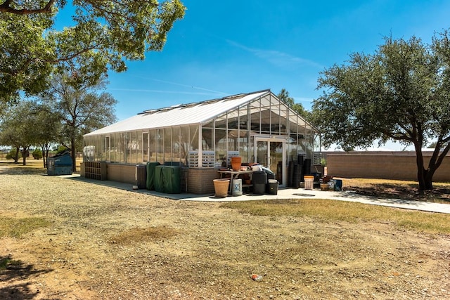 back of property with an exterior structure, an outdoor structure, and fence