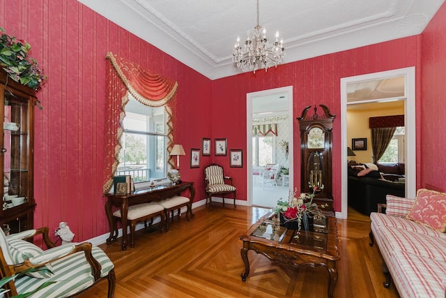 living area featuring baseboards, a chandelier, and a wealth of natural light