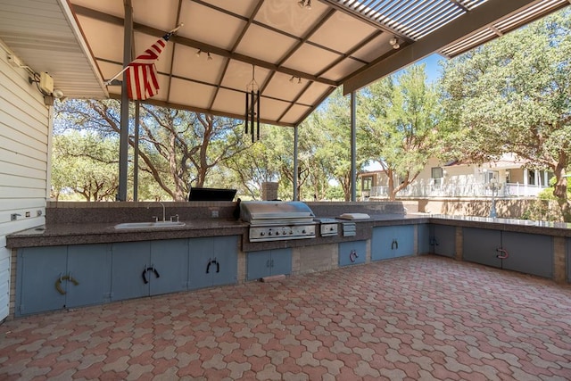 view of patio / terrace with exterior kitchen, grilling area, and a sink