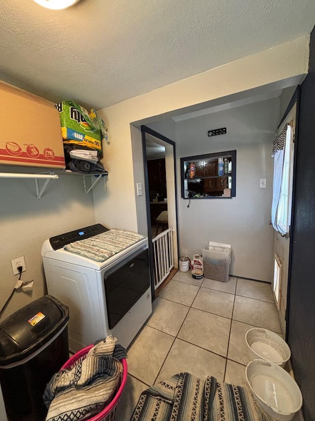 3103 Hill Ave, Snyder, TX 79549 - laundry room featuring washer / clothes dryer, light tile patterned floors, and a textured ceiling