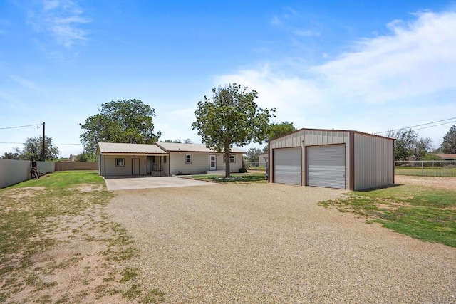 306 S Moss Lake Rd, Big Spring, TX 79720 - view of front of home with driveway, an outbuilding, and a detached garage