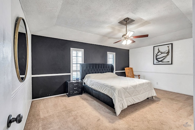 carpeted bedroom with a ceiling fan and a textured ceiling