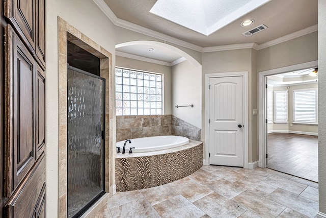 bathroom with ornamental molding and separate shower and tub