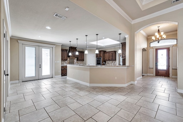 kitchen with premium range hood, french doors, tasteful backsplash, hanging light fixtures, and ornamental molding