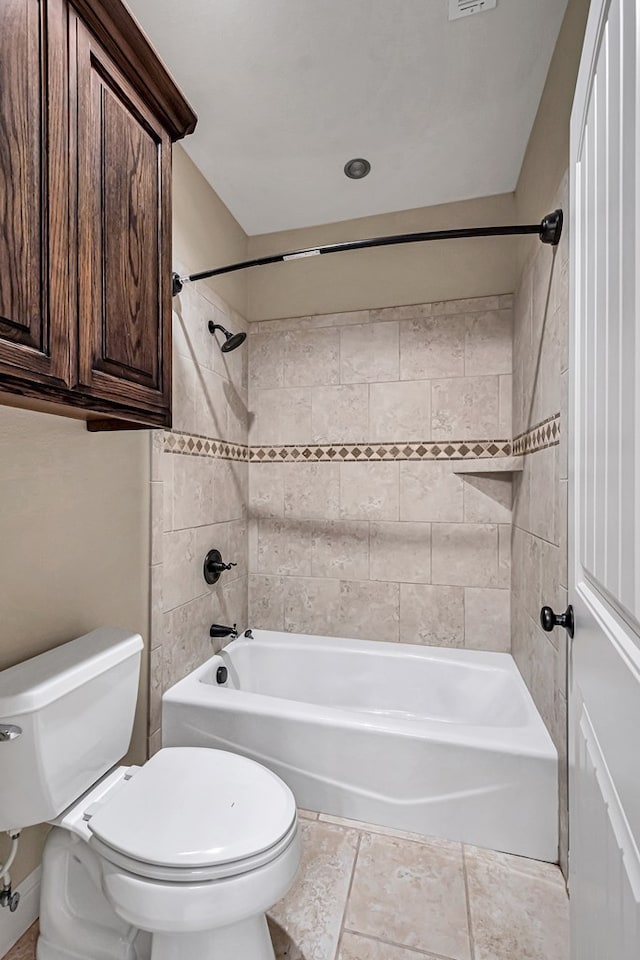 bathroom with tiled shower / bath combo and toilet