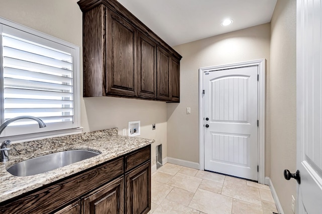 laundry area featuring electric dryer hookup, sink, hookup for a washing machine, and cabinets