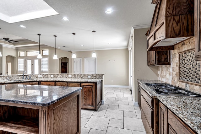 kitchen with dark stone countertops, decorative light fixtures, and a kitchen island