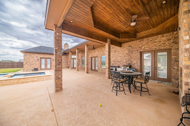 view of patio / terrace with ceiling fan, french doors, and a hot tub