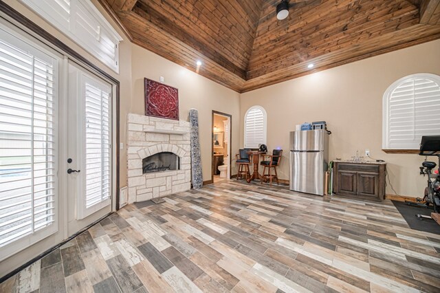 living room featuring french doors, high vaulted ceiling, wood-type flooring, a fireplace, and wood ceiling