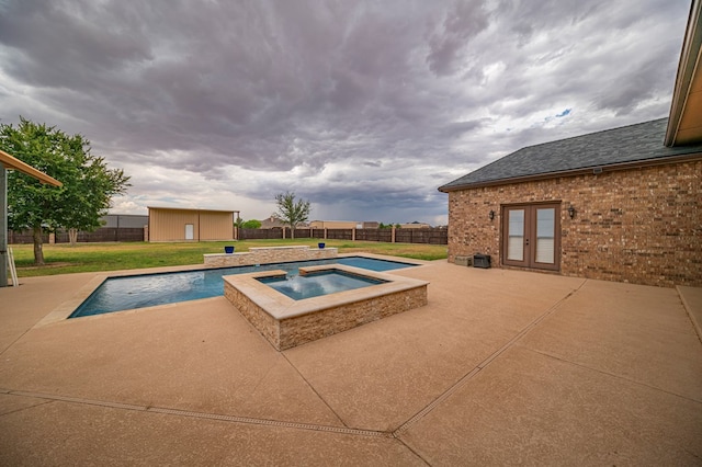 view of swimming pool with a patio area, a yard, an in ground hot tub, and french doors