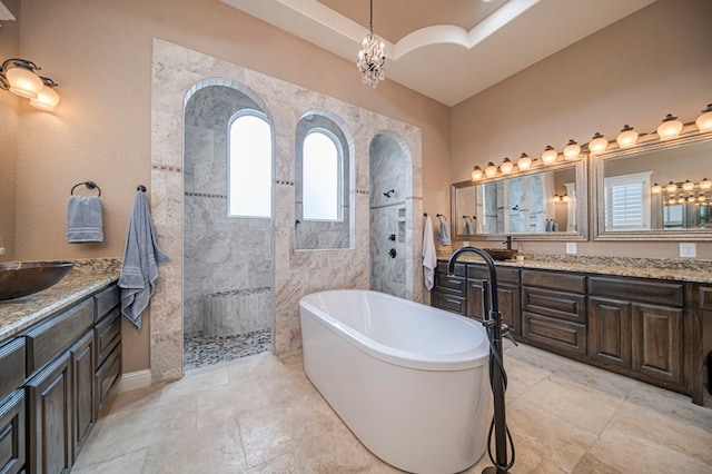 bathroom featuring plus walk in shower, vanity, and a chandelier