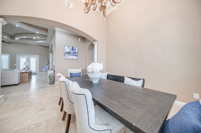 dining space with a notable chandelier, a high ceiling, and french doors