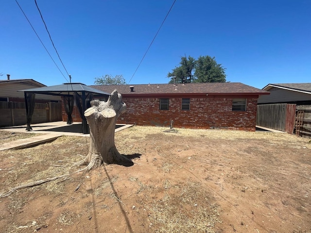 4705 Ric Dr, Midland, TX 79703 - rear view of property with a gazebo, fence, a patio, and brick siding