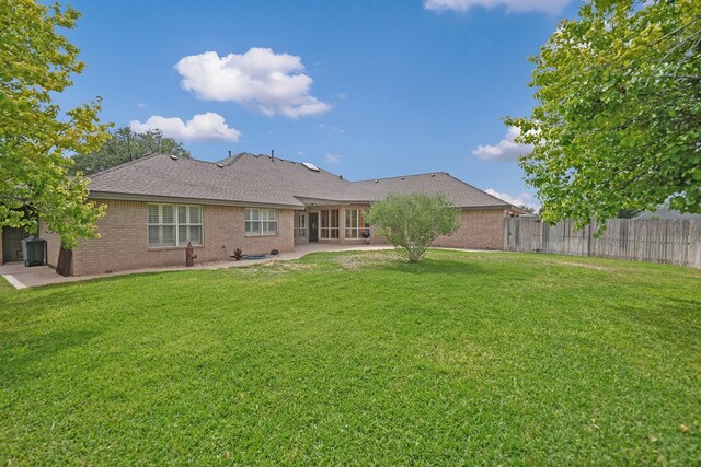 5810 Sterling Pl, Midland, TX 79707 - back of property featuring a patio, brick siding, and roof with shingles