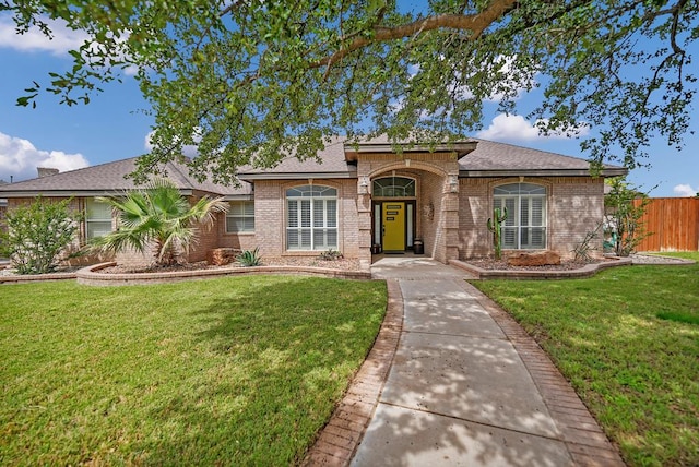 view of front of house featuring brick siding and roof with shingles