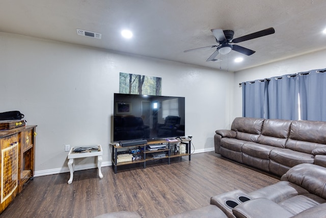 living room with baseboards, visible vents, wood finished floors, and ceiling fan