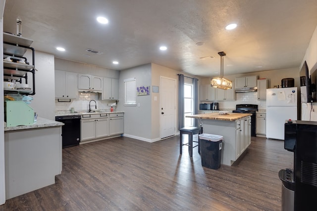 kitchen with black appliances, visible vents, decorative backsplash, and recessed lighting