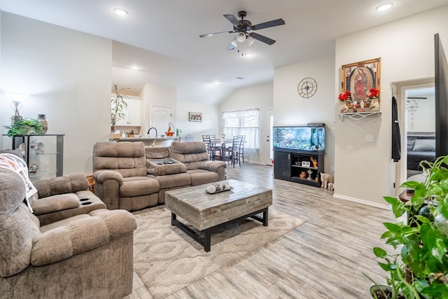 living room with ceiling fan, lofted ceiling, and light hardwood / wood-style floors