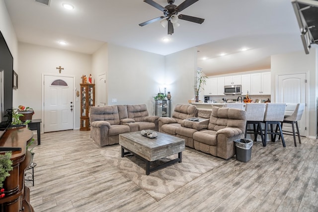 living room featuring ceiling fan and light hardwood / wood-style floors