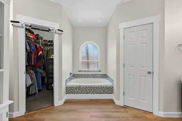 5604 Crowley Blvd, Midland, TX 79707 - bathroom featuring a bath, wood finished floors, baseboards, and a walk in closet