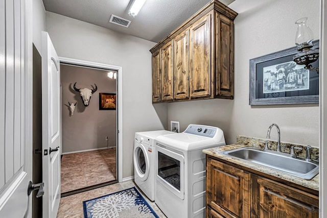 laundry room featuring a sink, cabinet space, light tile patterned floors, visible vents, and washer and dryer
