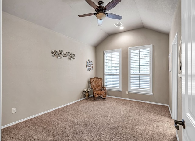 unfurnished room with lofted ceiling, visible vents, ceiling fan, baseboards, and carpet
