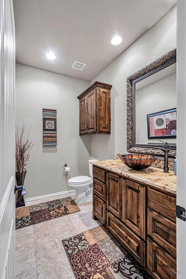 bathroom featuring recessed lighting, vanity, toilet, visible vents, and baseboards
