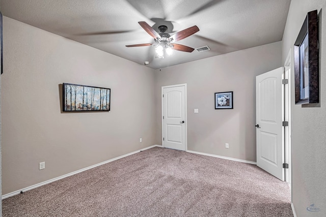 unfurnished bedroom with visible vents, ceiling fan, carpet, and baseboards