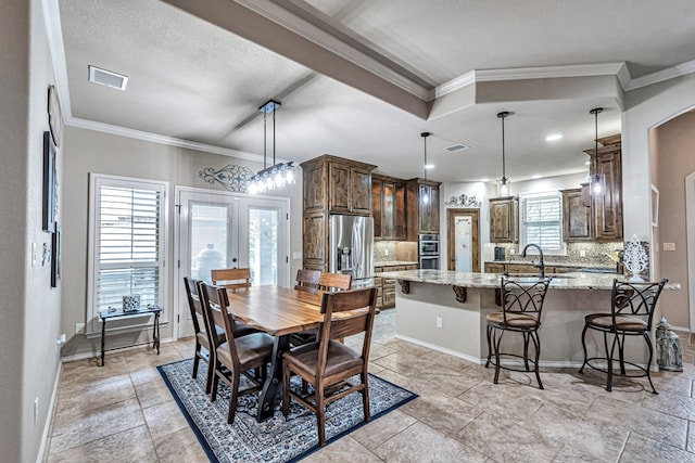 dining space featuring baseboards, visible vents, french doors, and crown molding