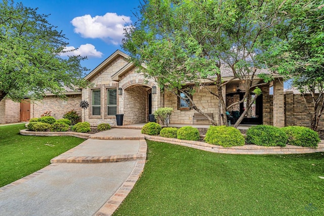 view of front of house featuring fence, a front yard, and stone siding