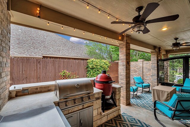 view of patio featuring area for grilling, ceiling fan, and a fenced backyard