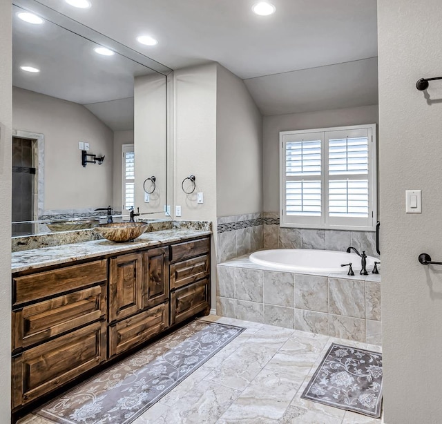 full bath with recessed lighting, marble finish floor, vanity, a garden tub, and lofted ceiling