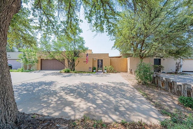 3615 W Wadley Ave, Midland, TX 79707 - pueblo-style home with stucco siding, a garage, and driveway
