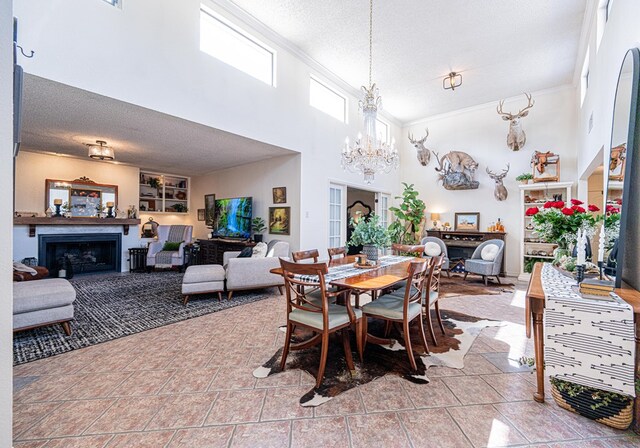 3615 W Wadley Ave, Midland, TX 79707 - dining space featuring a chandelier, a textured ceiling, a fireplace, crown molding, and a high ceiling