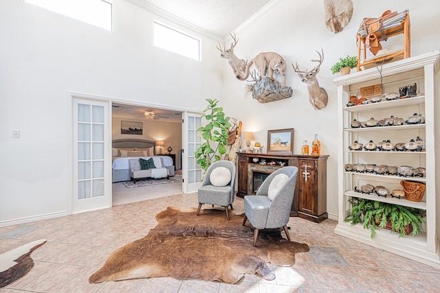 3615 W Wadley Ave, Midland, TX 79707 - sitting room with crown molding, a high ceiling, and a glass covered fireplace