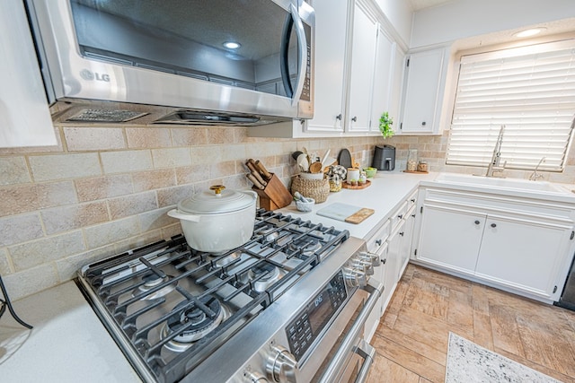 3615 W Wadley Ave, Midland, TX 79707 - kitchen featuring stainless steel appliances, white cabinetry, light countertops, and backsplash