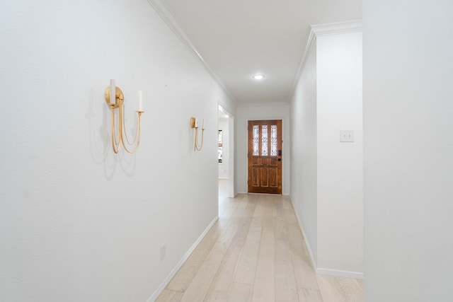 hall with ornamental molding and light hardwood / wood-style flooring