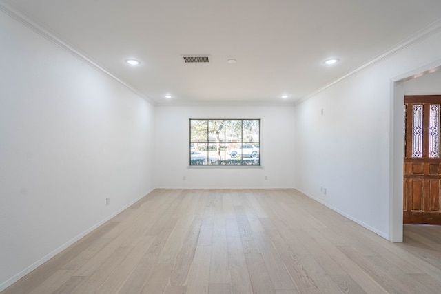 empty room featuring light hardwood / wood-style floors and crown molding