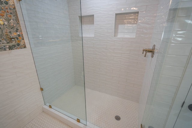 bathroom featuring a tile shower and tile patterned floors