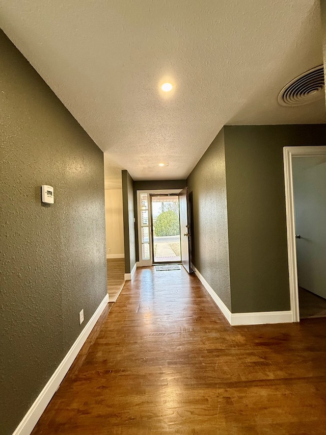 doorway to outside featuring wood-type flooring and a textured ceiling