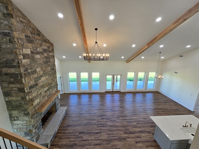 unfurnished living room featuring high vaulted ceiling, sink, beam ceiling, and a fireplace