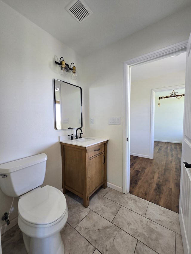 bathroom with toilet, tile patterned floors, and vanity