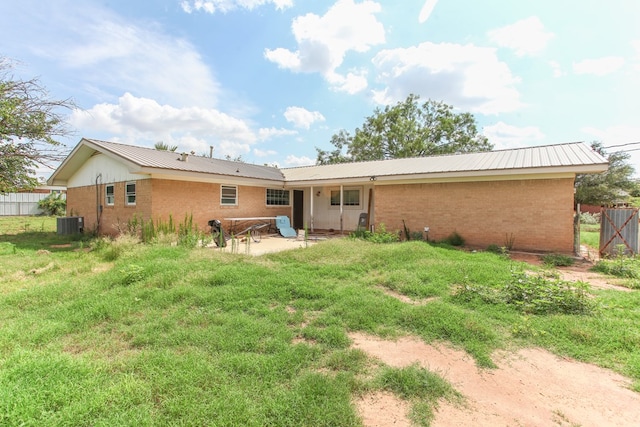 207 W Robinson Rd, Big Spring, TX 79720 - rear view of house with brick siding, a patio area, and a metal roof
